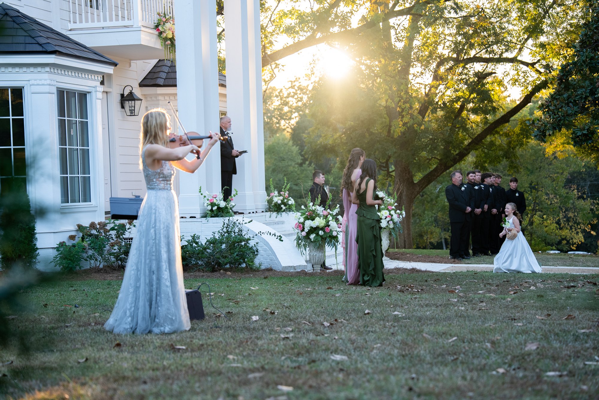 Margarita playing violin in a sunlit garden